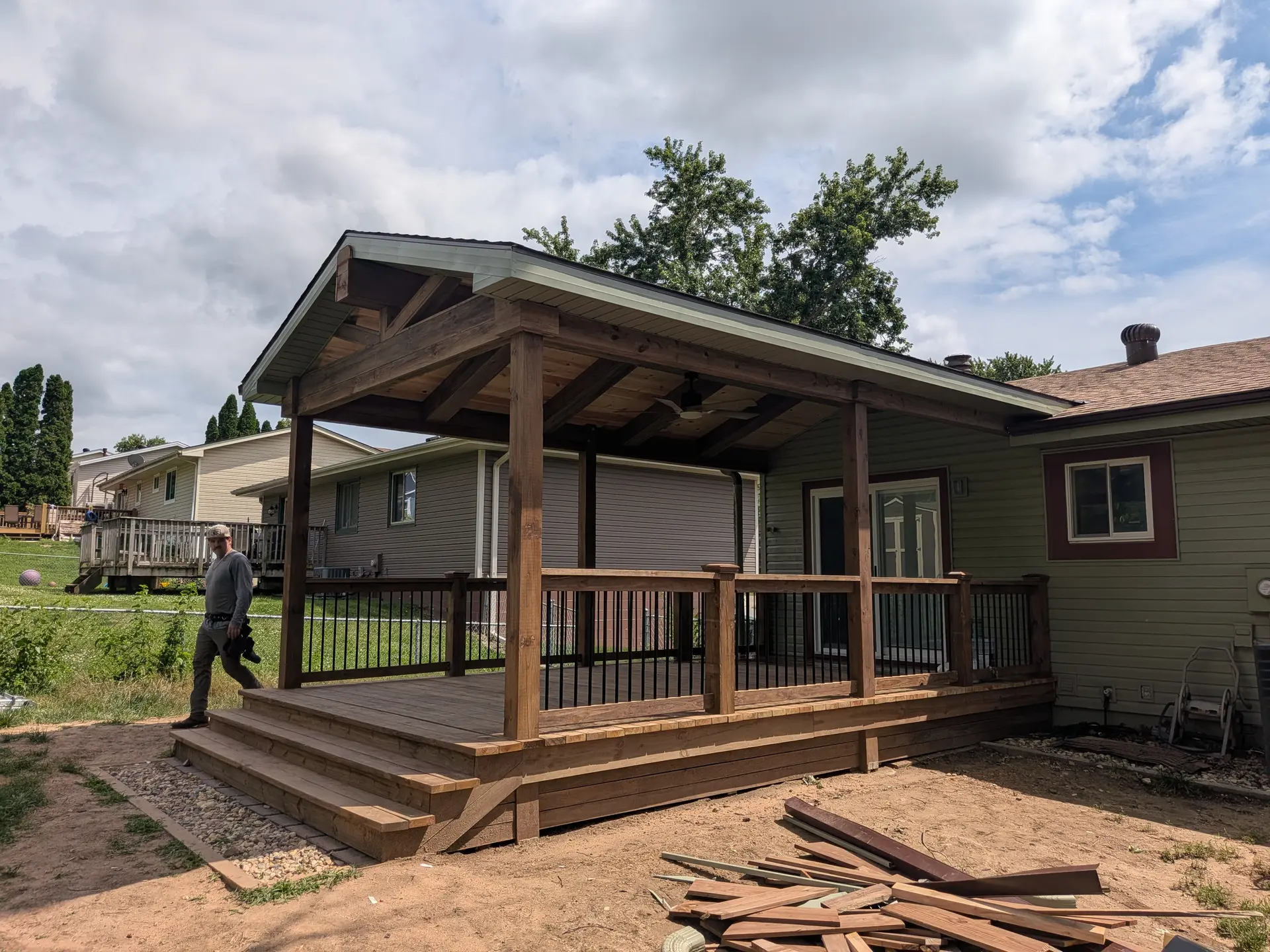 Nearly finished covered deck addition with dark-stained timber framing