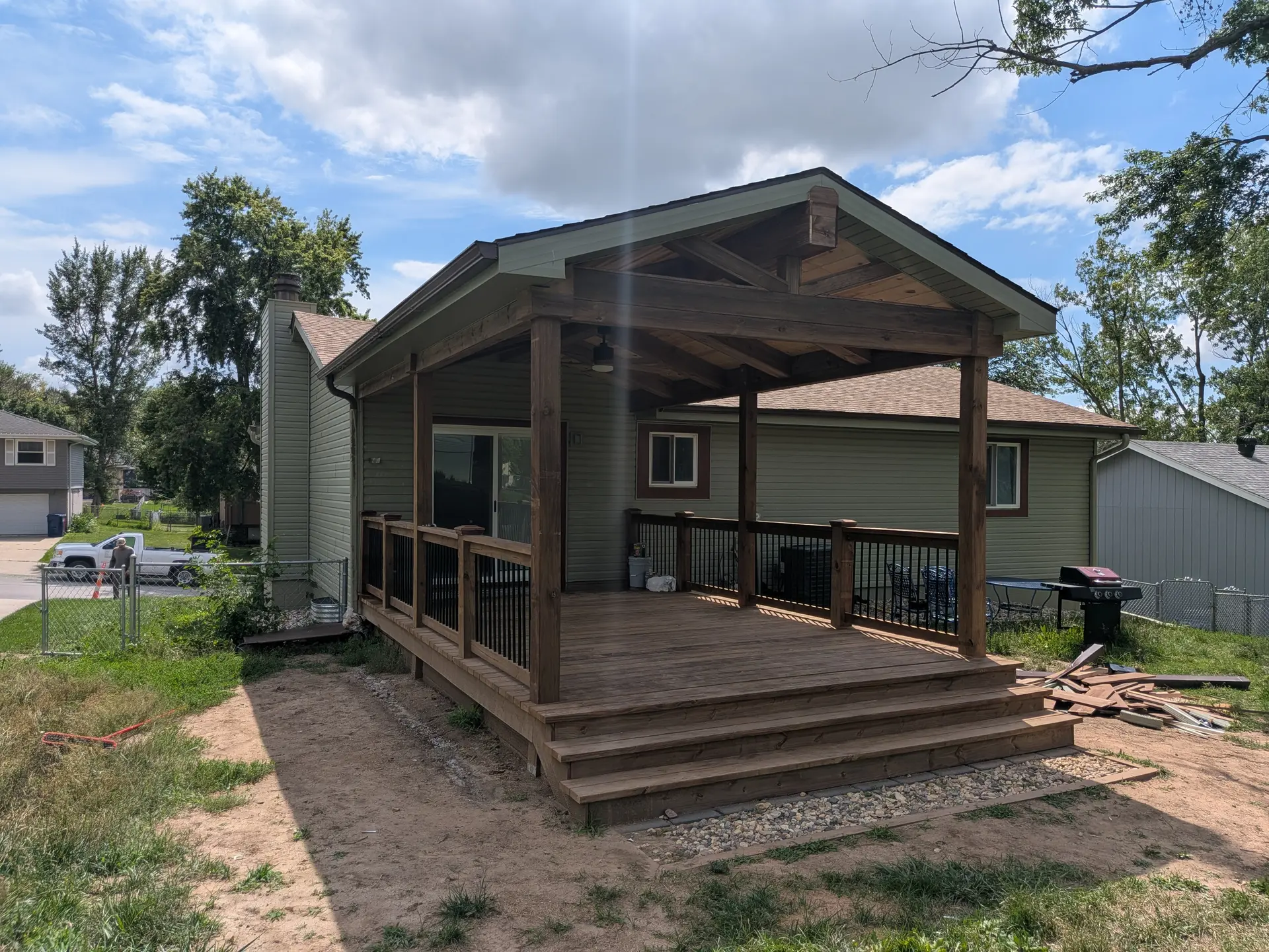 Covered wooden deck with a gabled roof and dark timber posts