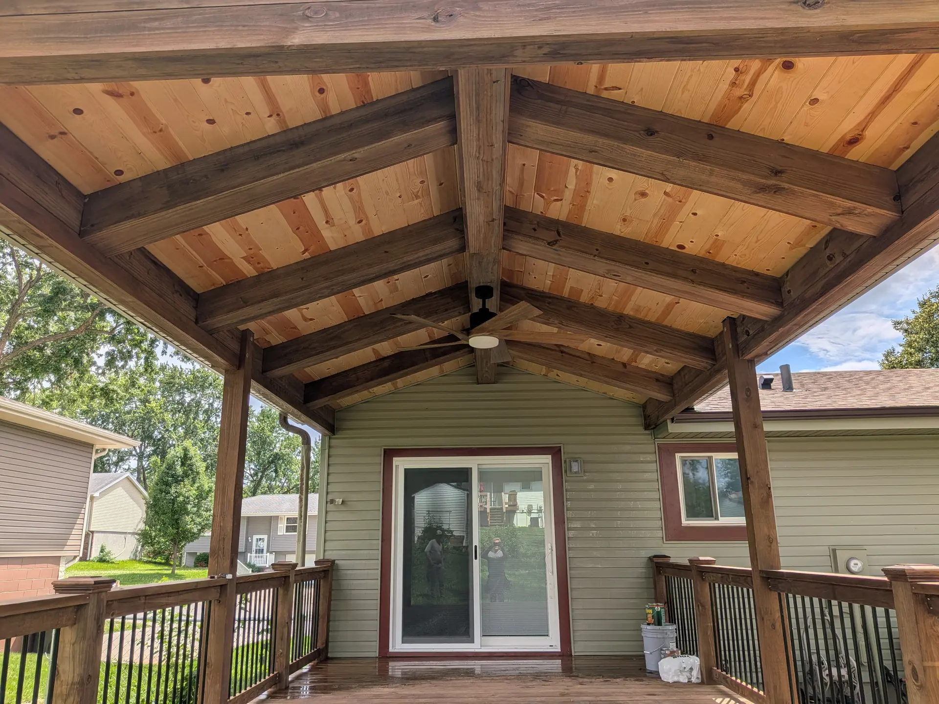 Covered deck interior with vaulted tongue-and-groove pine ceiling and timber beams